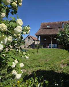 a house with a yard with white flowers at Le Bel Air en Berry in Reigny