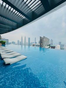 a pool on the roof of a building with a city at Eaton Delight Residences in Kuala Lumpur