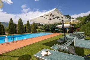 a pool with a white umbrella and a table and chairs at Campo Grande by VacaVilla in Santa Cristina