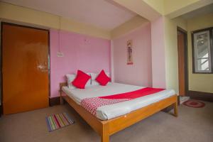 a bedroom with a bed with red pillows at Hotel O Siljong in Gangtok