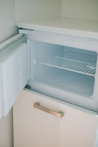 an empty refrigerator with its door open with a drawer at Slow Moments in Brussels in Brussels
