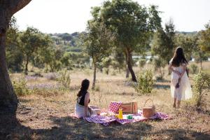 two girls sitting on a picnic blanket under a tree at Octant Evora in Évora +90 photos