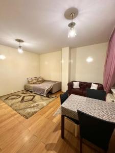 ein Wohnzimmer mit einem Bett und einem Tisch in der Unterkunft Main Street Apartments in Chişinău