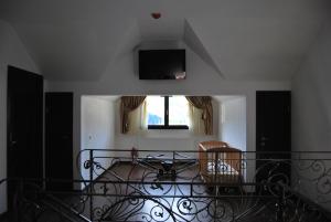 ドゥラウにあるPensiunea Goldのベッドルーム1室(ベッド1台、壁掛けテレビ付)