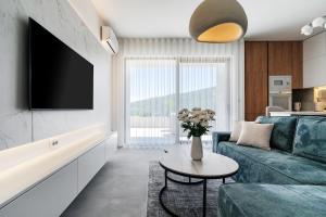 un salon avec un canapé et une télévision dans l'établissement New luxes white apartments, à Baošići