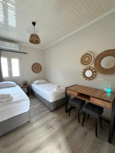 a bedroom with two beds and a wooden table at Geropalas Spacious Garden House in Vlachopoulátika