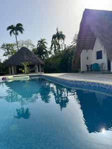 a swimming pool in front of a house with a building at Charming Bungalow with Pool in Sosúa +10 photos