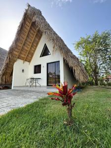 a small house with a thatched roof at Charming Bungalow with Pool in Sosúa