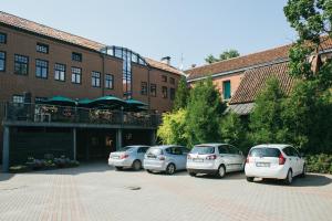 three cars parked in a parking lot in front of a building at Kuldigas Metropole in Kuldīga