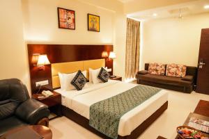 a hotel room with a bed and a couch at Hotel Sai Jashan Shirdi - Where blessings & comfort meet in Shirdi