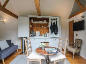 a kitchen and living room with a table and chairs at Little Barn in Royston