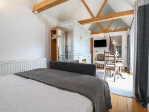 a bedroom with a bed and a dining room at Little Barn in Royston