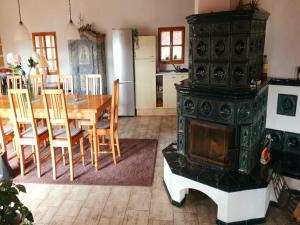 a living room with a fireplace and a dining room table with a stove at Private Pool Villa in Stupna in Pecka