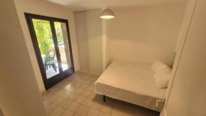 1 Schlafzimmer mit einem Bett und einem Balkon mit einem Stuhl in der Unterkunft Location de vacances in Santa-Maria-Poggio