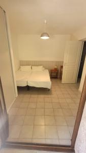 ein Schlafzimmer mit einem Bett und einem gefliesten Boden in der Unterkunft Location de vacances in Santa-Maria-Poggio + 7 Fotos