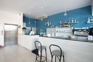 a bar with two chairs and a counter with blue walls at HOTEL CONTI in San Mauro a Mare