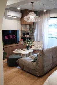 バンコクにあるThe Shantipan Jasmine - Cozy City Retreat 400m from BTS Stationのソファとテーブルのあるリビングルーム +15枚の写真
