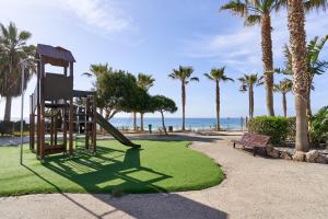 a playground with a slide and a bench on the beach at Jardine del Mar Torrox in Torrox Costa