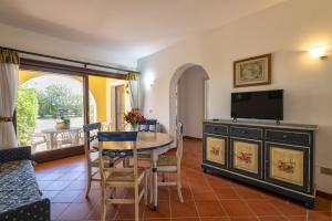 een woonkamer met een tafel en een tv bij Trilocale Fiordaliso in Stintino