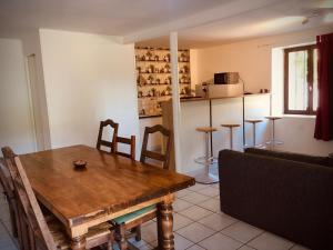 a kitchen and dining room with a wooden table and chairs at Au bord de l eau in Pesmes