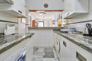 a kitchen with white cabinets and a counter top at Jardine del Mar Torrox in Torrox Costa