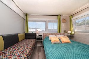 Un dormitorio con dos camas en un remolque. en Mobilhome rénové Sarzeau, en Sarzeau