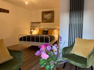 a bedroom with a bed and a vase of flowers at Fishermans Cottage at The Old Library in Aberystwyth