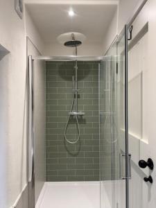 a bathroom with a shower with green tile at Fishermans Cottage at The Old Library in Aberystwyth