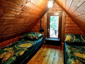 a bedroom with two beds in a wooden cabin at Baza noclegowa "Warownia" in Srebrna Góra