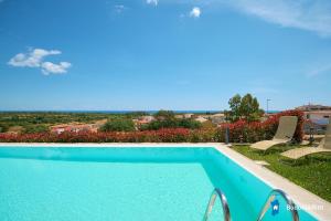 a swimming pool with two lawn chairs next to it at Villa con piscina by budoniaffiti in Budoni