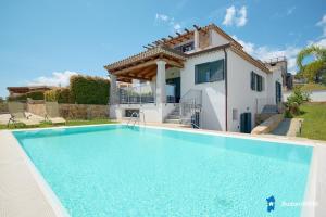a villa with a swimming pool in front of a house at Villa con piscina by budoniaffiti in Budoni