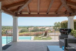 a wooden pergola with a view of a pool at Villa con piscina by budoniaffiti in Budoni
