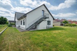 a white house with a staircase in a yard at Ferienwohnung Auszeit in Kargow