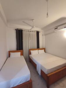 two beds in a small room with at Summer Dream in Badulla