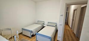 two twin beds in a room with a hallway at Mirta Rooms in Malcesine