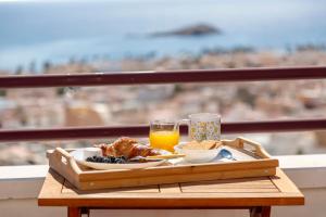Una bandeja de comida para el desayuno en una mesa en un balcón. en El Mirador, en Carboneras