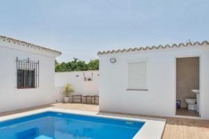 a white house with a swimming pool and a toilet at Villa Castro in Vejer de la Frontera