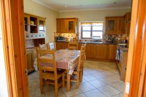 a kitchen with a table and chairs in it at Aberystwyth Enlli Cottage in Llanilar