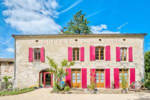 an old building with pink shutters on it at Logement Le Buffet De La Gare in Falgueyrat