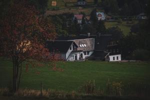 a white house on a hill with a green field at Landhaus Bärenstein - Pano-Blick 1 in Bärenstein