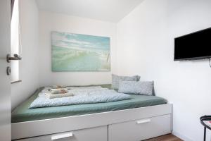 Un dormitorio con una cama y un televisor en una pared. en Lieblingsplatz, en Wunstorf