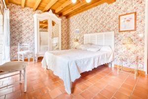 ein Schlafzimmer mit einem Bett in einem Zimmer mit Tapete in der Unterkunft Maison de Campagne à Cunèges in Cunèges + 28 Fotos