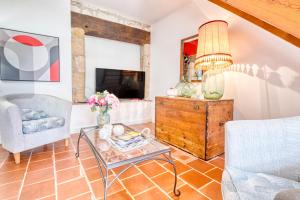 ein Wohnzimmer mit Tisch und Fernseher in der Unterkunft Maison de Campagne à Cunèges in Cunèges