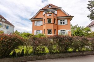 康斯坦茨Rotes Haus über den Weinbergen的一座橙色的房子，上面有一座钟