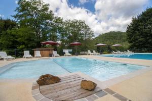- une piscine avec des rochers au milieu dans l'établissement Mobilhome Du Bonheur, à Saint-Pompont