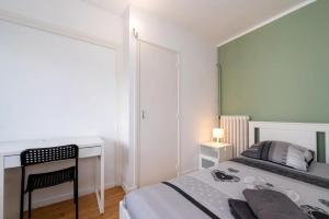 una piccola camera da letto con un letto e una scrivania di Appartement 3 chambres Wifi Lorient Centre a Lorient