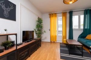 un soggiorno con un divano e una televisione di Appartement 3 chambres Wifi Lorient Centre a Lorient