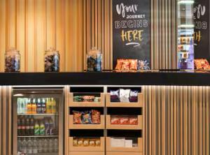 a counter in a store with a refrigerator with food at Hampton By Hilton Wroclaw Airport in Wrocław