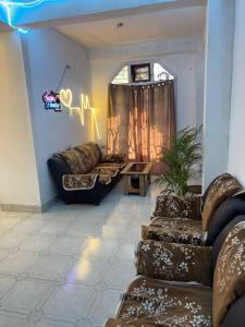 a living room with leather couches and a window at Sunrise Homestay in Jāmb