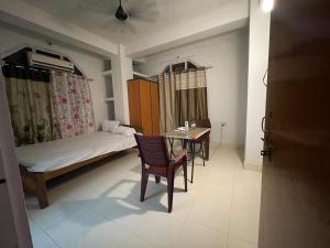 a room with a bed and a table and a table and chairs at Sunrise Homestay in Jāmb